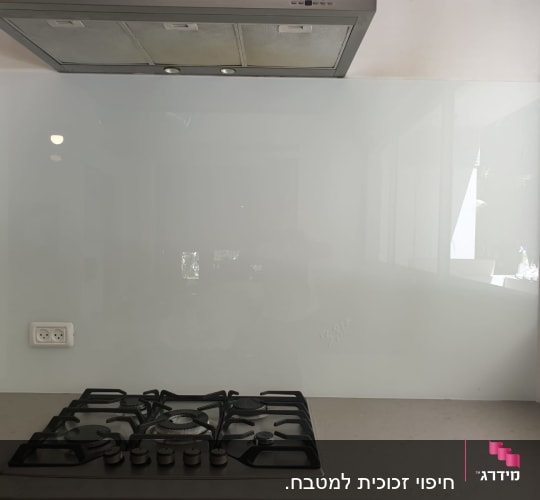 זכוכית שקופה מאחורי כיריים במטבח מודרני